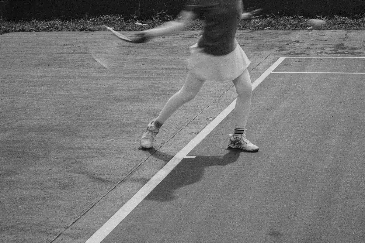 Giocatore di tennis in allenamento durante esercizi di footwork e reattività in campo