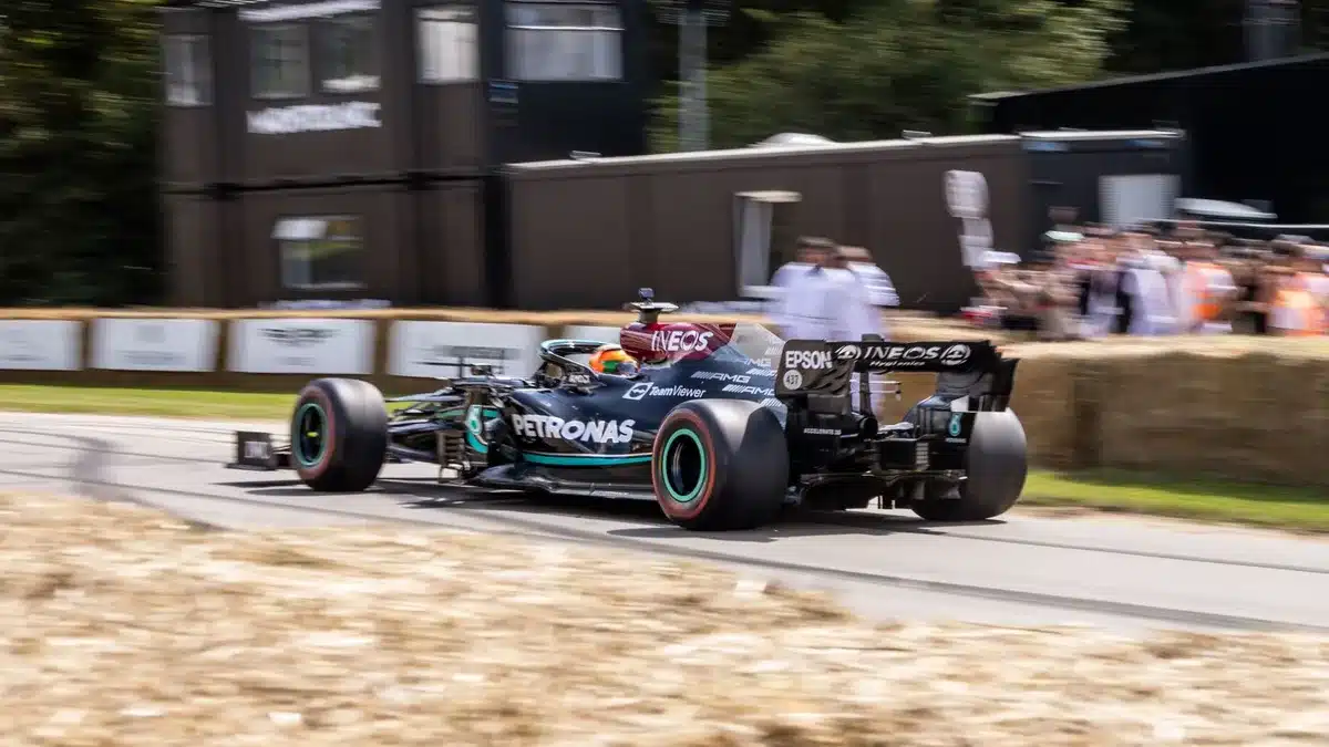 Auto da corsa in Formula 1 affronta una curva inclinata con spettatori in tribuna sullo sfondo