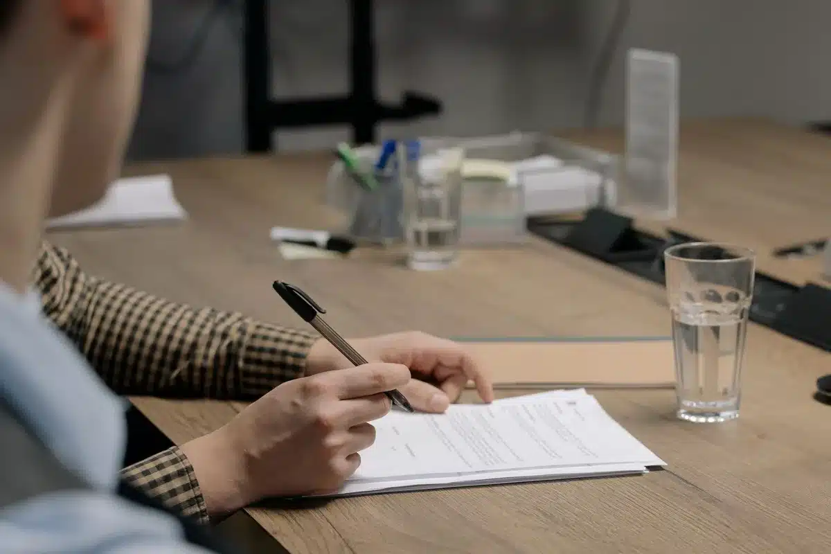 Firma di un contratto di trasferimento calcistico con documenti e penna su una scrivania