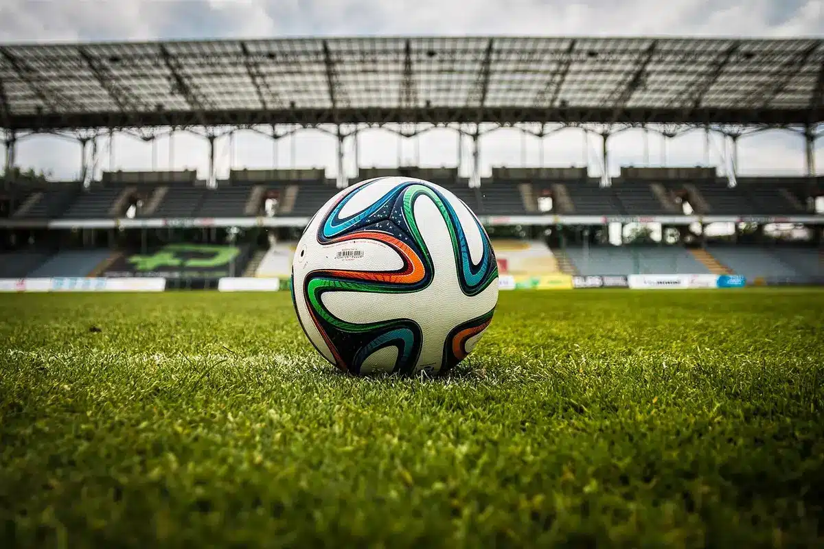 Tifosi anonimi con sciarpe viola e azzurre in uno stadio al crepuscolo