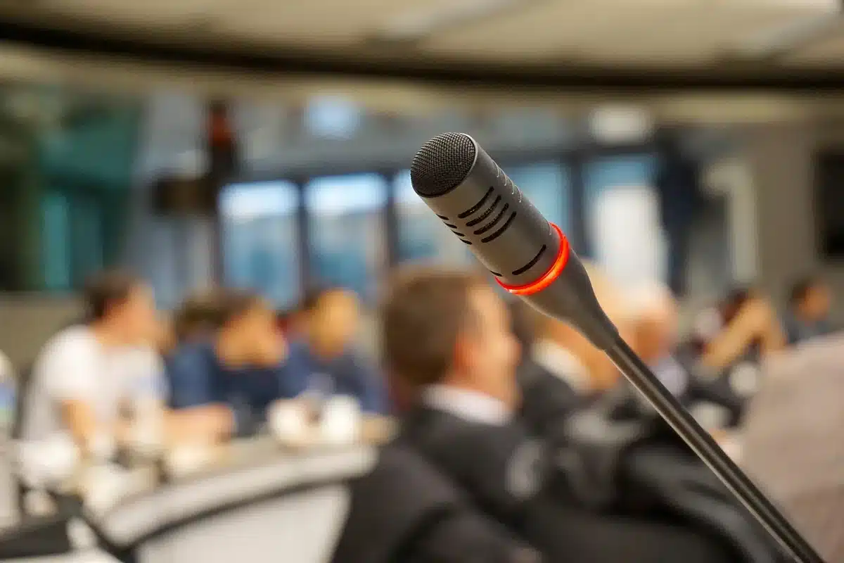 Sala conferenze con microfono vuoto e cartelle sul tavolo