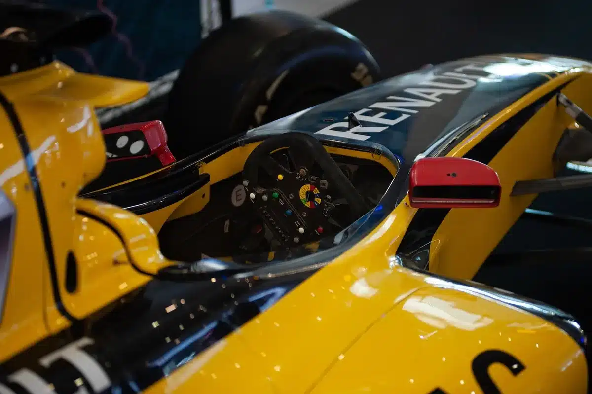 Auto da corsa in curva ad alta velocità su circuito con tribune piene di spettatori