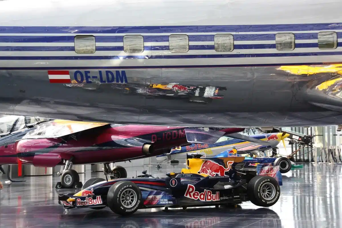 Meccanici in garage F1 al lavoro con documenti contrattuali e schermi digitali