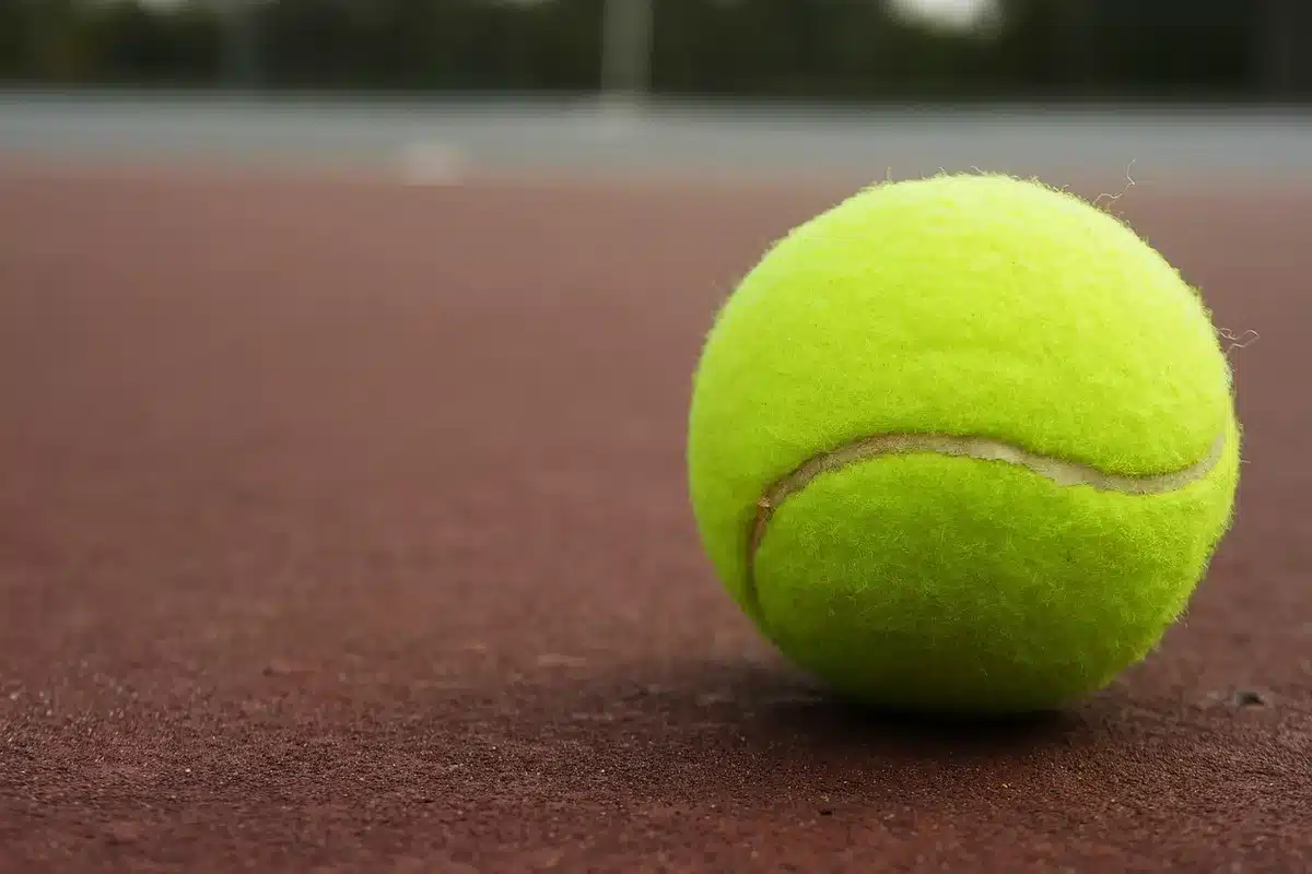 Partita di tennis in doppio su campo all'aperto con giocatori e pubblico
