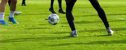 Campo da allenamento con pali della porta e clipboard sul bordo, silhouette sullo sfondo