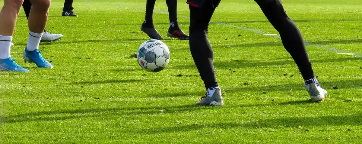 Campo da allenamento con pali della porta e clipboard sul bordo, silhouette sullo sfondo