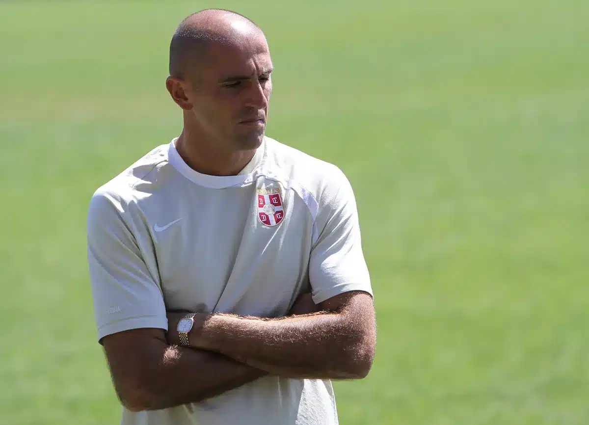 Allenatore mostra piano tattico su lavagna durante la preparazione della partita