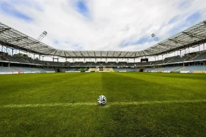 Tunnel dello stadio con pallone e guanti sul bordo del campo alla luce del giorno
