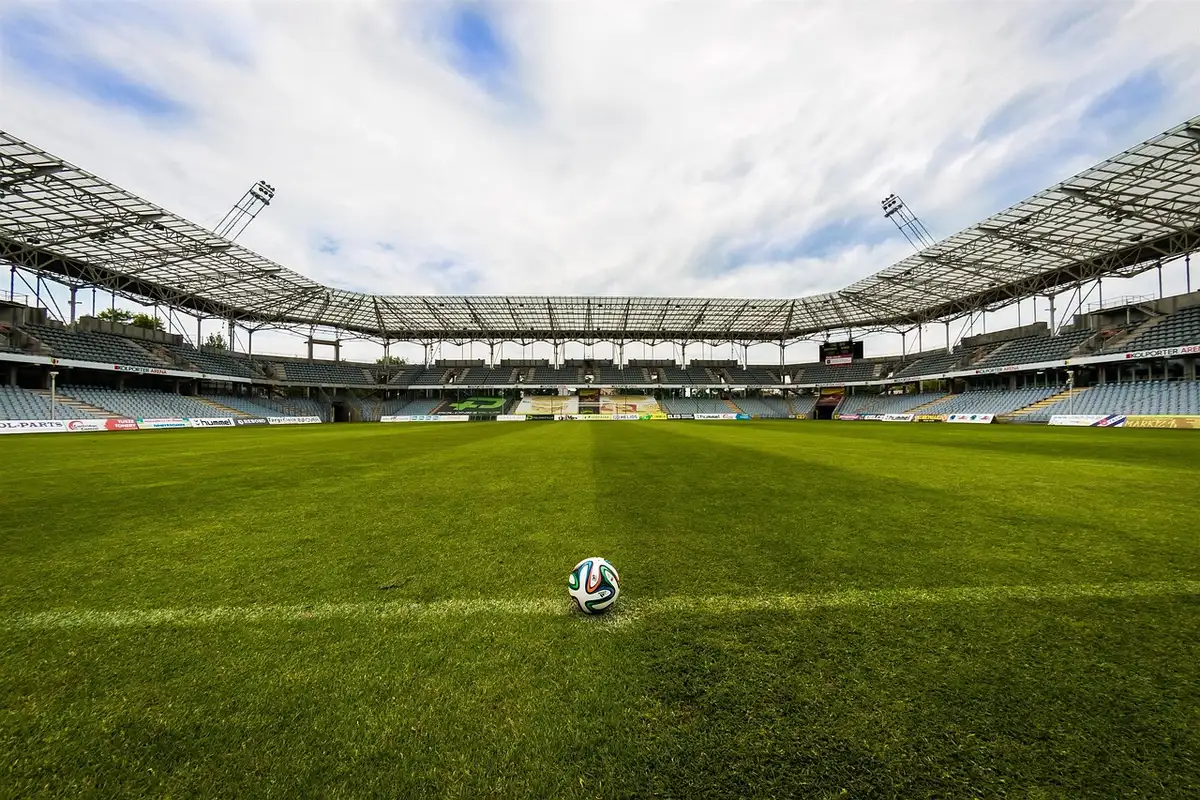 Tunnel dello stadio con pallone e guanti sul bordo del campo alla luce del giorno