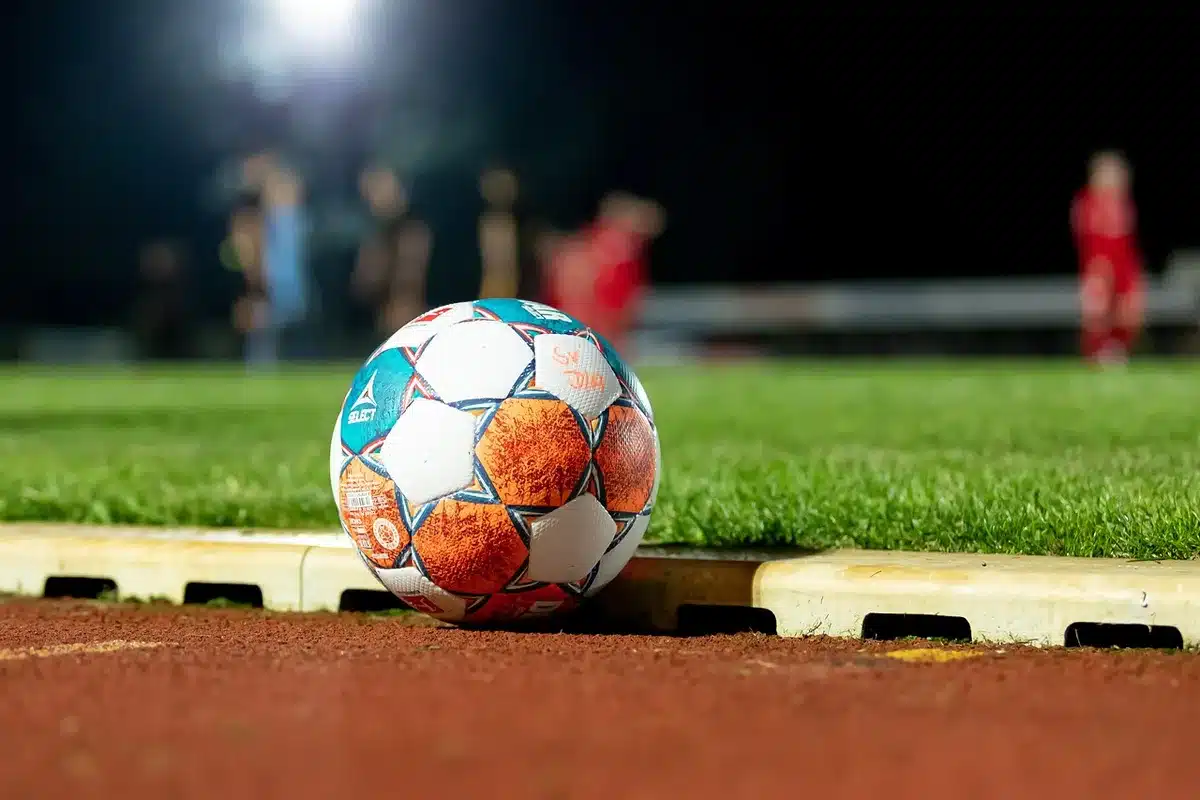 Tifosi anonimi con sciarpa su una balaustra nello stadio, atmosfera di attesa