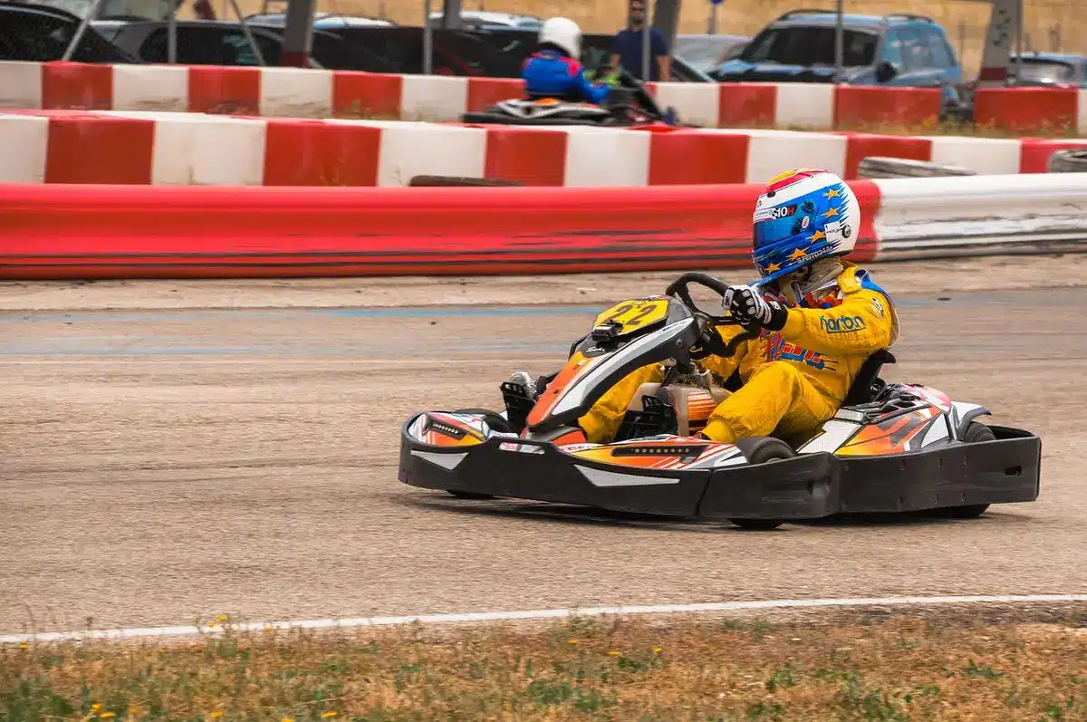 Giovani piloti in kart con caschi in fila