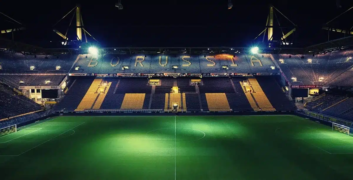 Ingresso dello stadio con sciarpe appoggiate alla ringhiera sotto i riflettori