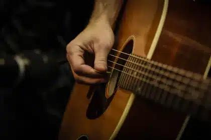 Musicista con chitarra in una piccola session acustica nel paddock, pubblico informale