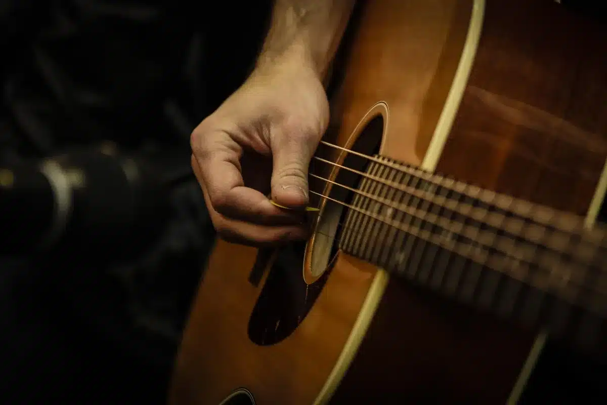 Musicista con chitarra in una piccola session acustica nel paddock, pubblico informale