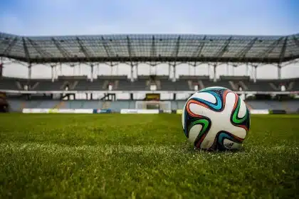 Tifosi anonimi del Genoa con sciarpe sotto i fari dello stadio