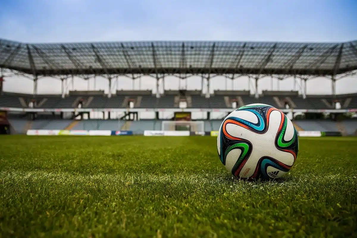 Tifosi anonimi del Genoa con sciarpe sotto i fari dello stadio