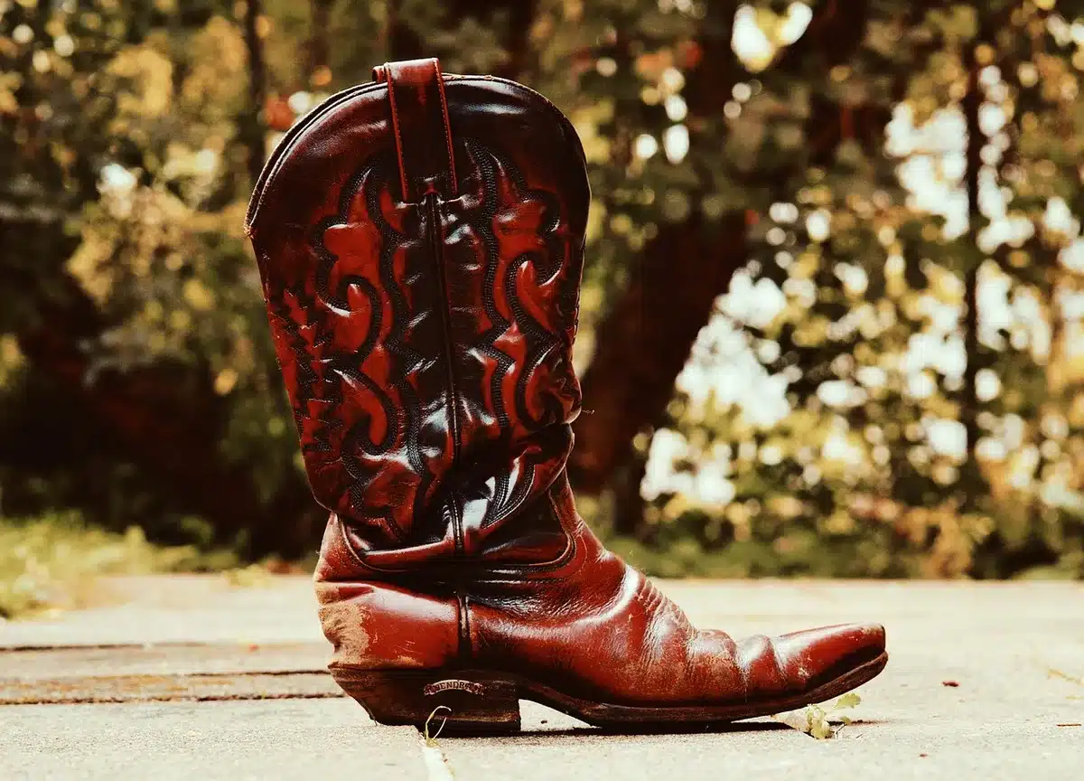 Silhouette con stivali da cowboy che esegue un moonwalk vicino ai box di una pista