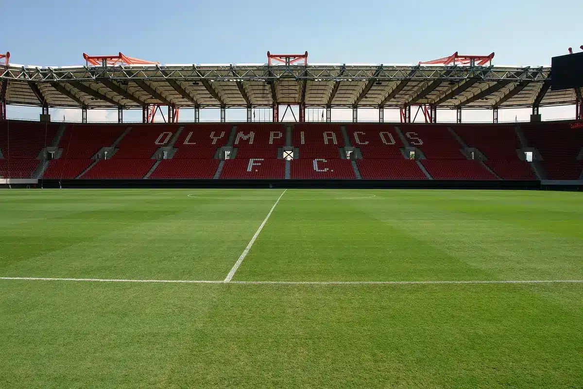 Stadio vuoto con sciarpa giallorossa e pallone in primo piano