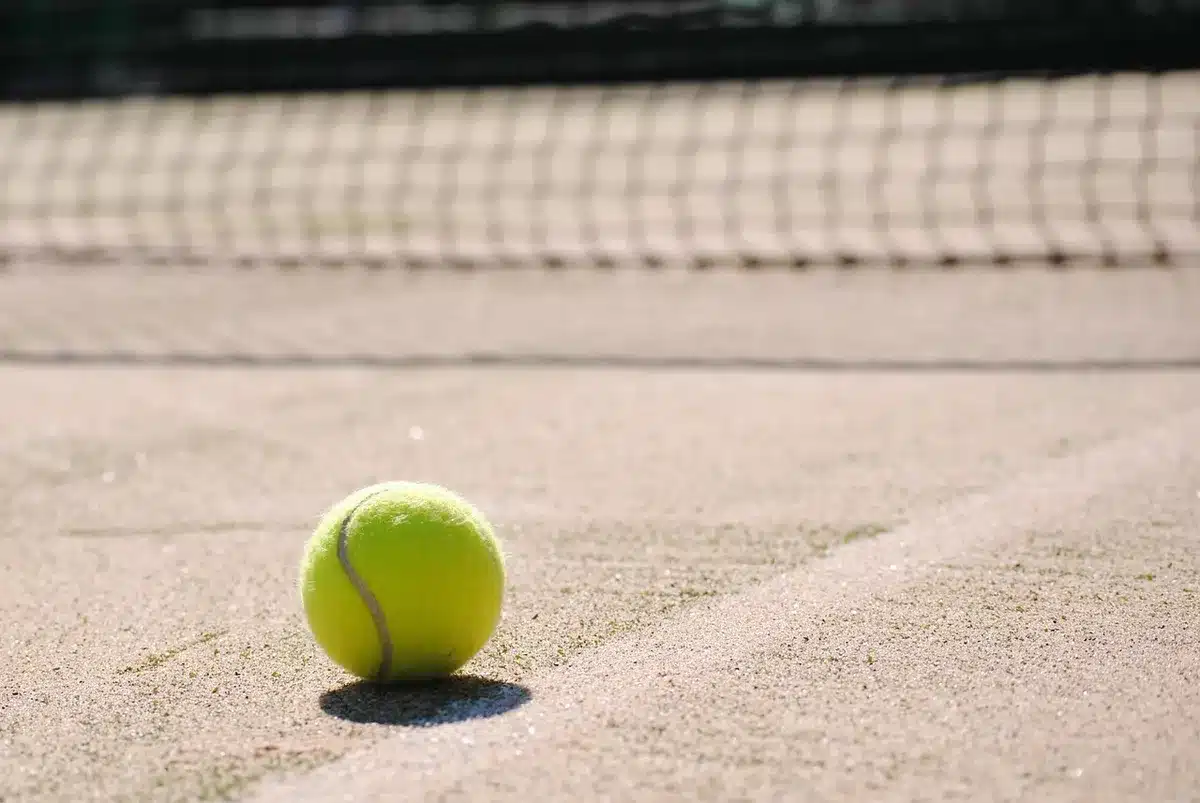 Striscioni e sponsorizzazioni intorno a un campo da tennis durante un torneo
