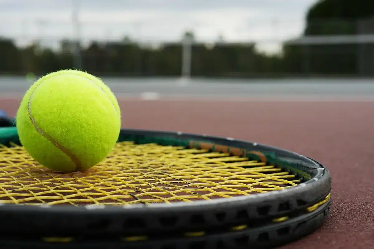 Giocatore di tennis che si allunga e si prepara, simbolo di gestione carico di lavoro
