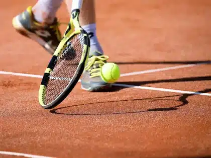 Campo da tennis vuoto con racchetta appoggiata al cancello e asciugamano, atmosfera pensosa